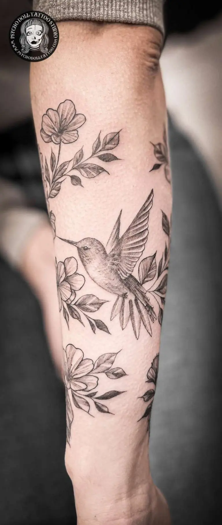 kukka tatuointi kyynärvarteen, jossa on kolibri